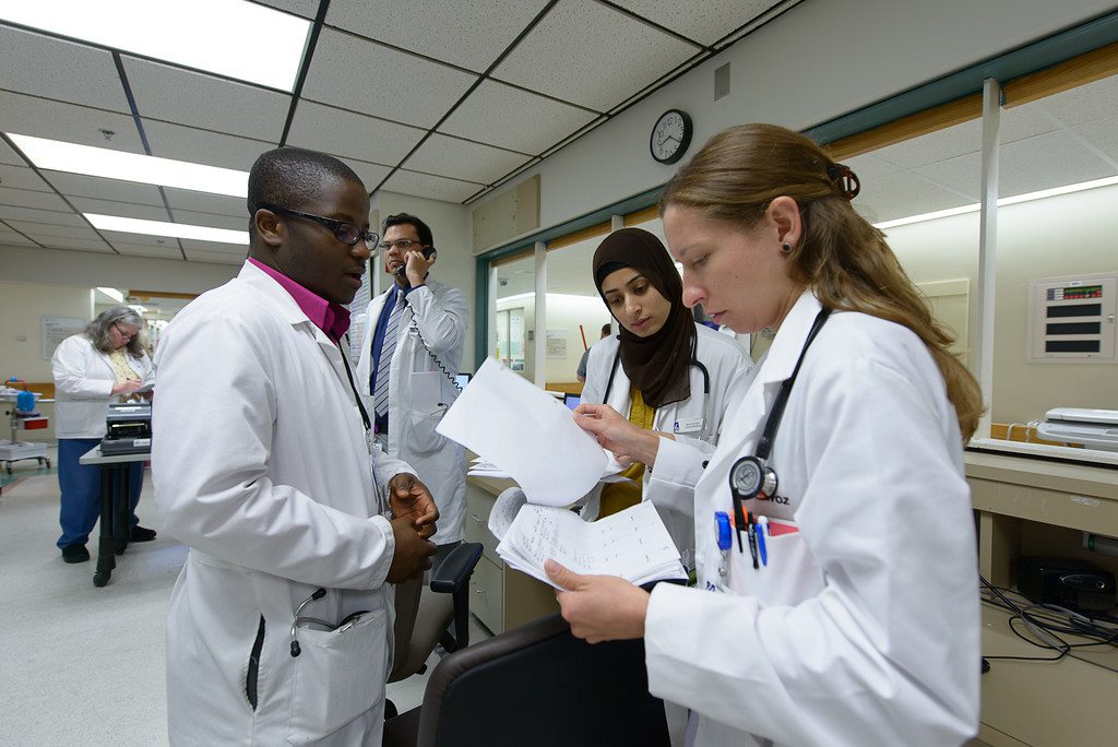 Doctors in White Coats Reviewing Paperwork