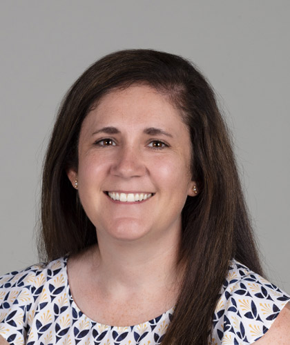 A person with long brown hair smiling