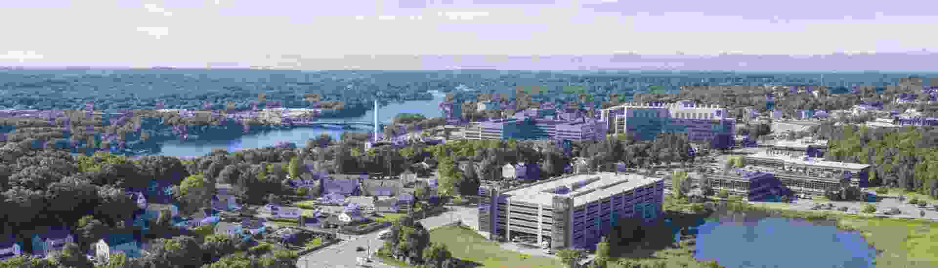 aerial view of a lake and buildings around UMASS Chan area