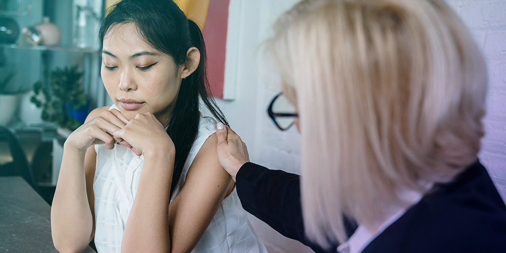 Asian woman being consoled