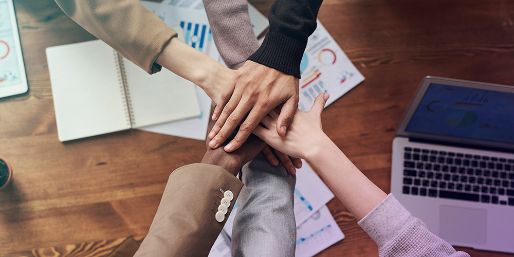 People with hands together in the center, concept of teamwork