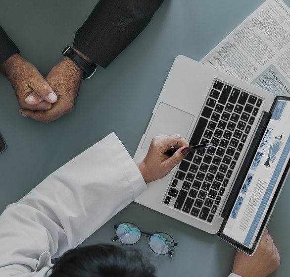 Doctor showing someone her screen on a laptop