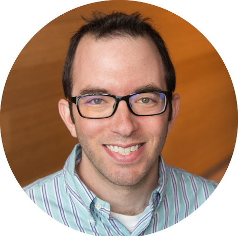 Circular portrait of Dr. Matthew Schwartz, who has short black hair and glasses and is wearing a striped button-down shirt and smiling.