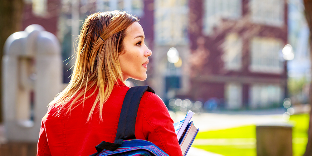 latino female walking on college campus