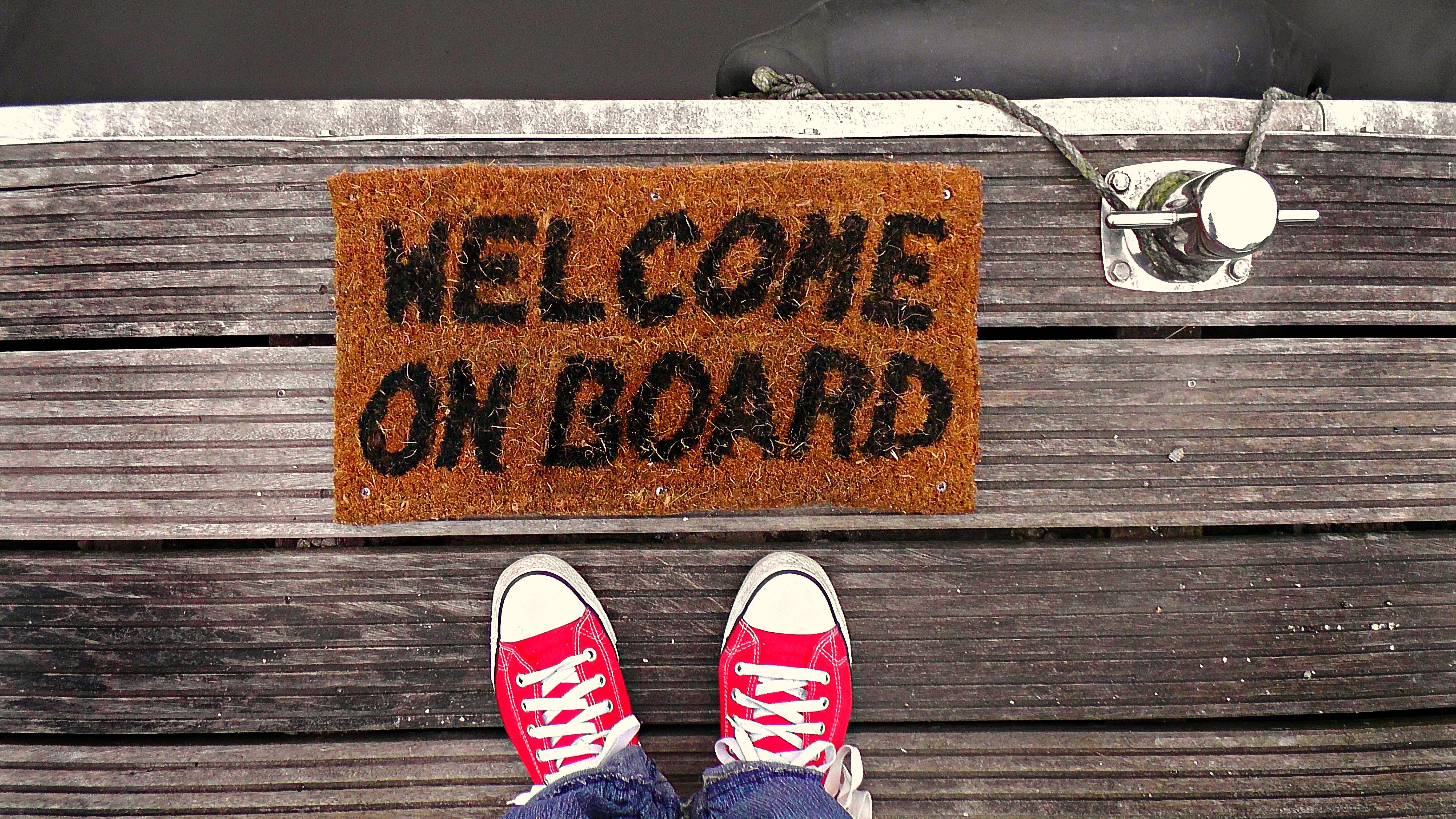 red shoes below a welcome mat that reads "welcome on board"