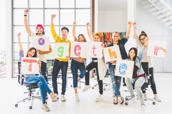 group of young adults holding signs that spell out the word together