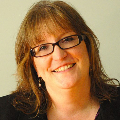 white woman with reddish blonde hair and glasses