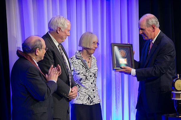 Neil Aronin (left) joins Chancellor Collins as he acknowledges Prentiss and Polly Higgins, who invested Aronin as the Higgins Family Professor of Neuroscience.