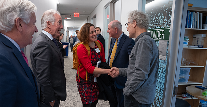 Renee Wegrzyn shaking hands with Victor Ambros inside of the new education and research building