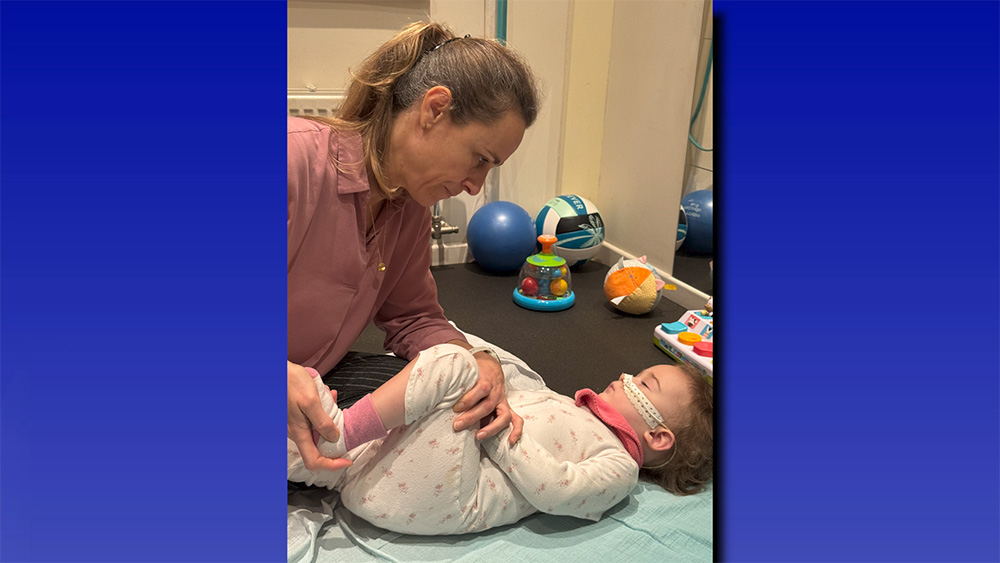 A physical therapist stretches Catherine’s leg during a session.