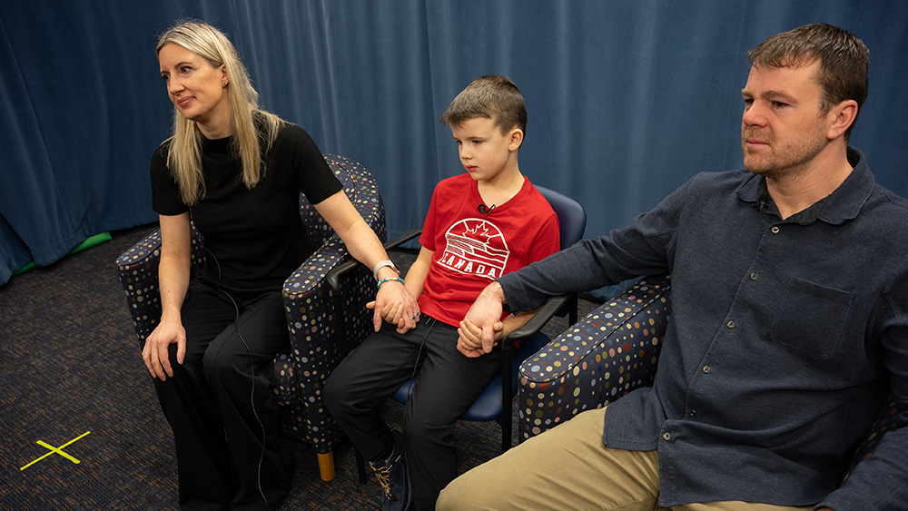 Anna, Jack and Richard Laidlaw, hold hands during their podcast interview.