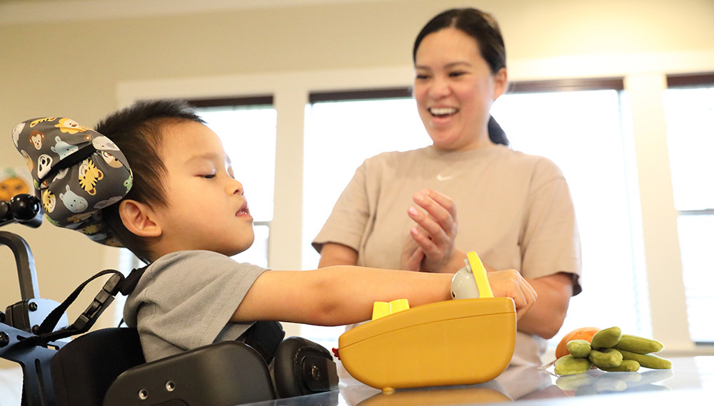 Linda Pham smiles as her son, Raiden, plays with his toys