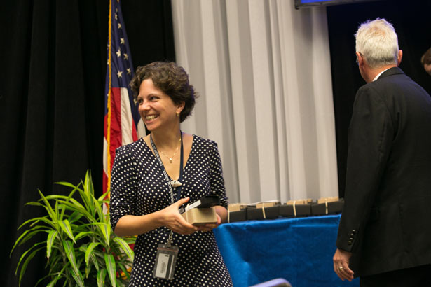 GSBS student Reka Haraszti, MD, of the Khvorova lab accepts business cards and a laser pointer from Dean Anthony Carruthers, at the ceremony recognizing students who passed the qualifying exam.