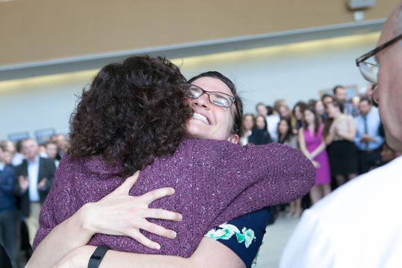 Julia Randall, SOM ’16, (right) gets a hug from Diane Blake, MD, after picking up her envelope.