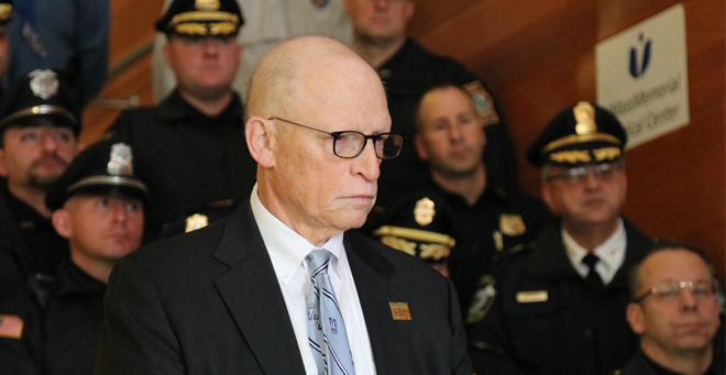 Michael Hirsh, flanked by local police officers, discusses the Goods for Guns program at a press conference on Wednesday, Dec. 13, at UMass Memorial Medical Center.