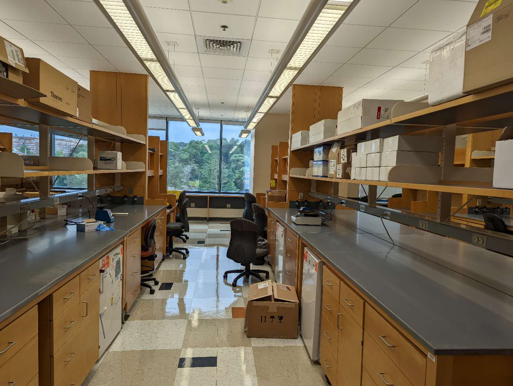 two empty lab benches with chairs, boxes