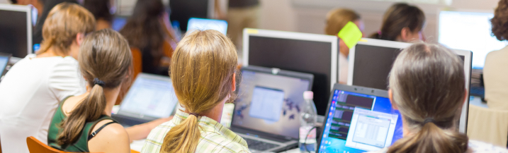 multiple people on laptops in a classroom